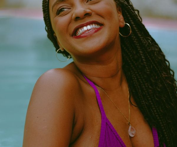 Person smiling and looking refreshed outdoors, representing well-being.